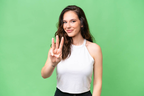 Jonge blanke vrouw geïsoleerd over geïsoleerde achtergrond gelukkig en tellen drie met vingers - Foto, afbeelding