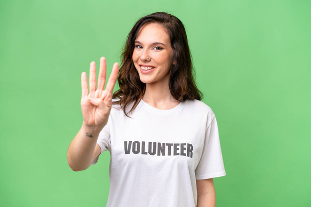 Giovane volontaria donna caucasica su sfondo isolato felice e contando quattro con le dita - Foto, immagini