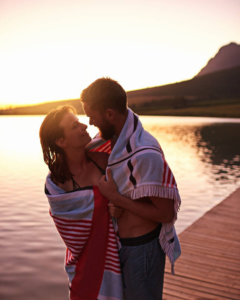 Lakeside love. láskyplný mladý pár v plavkách zabalený v ručníku u jezera - Fotografie, Obrázek