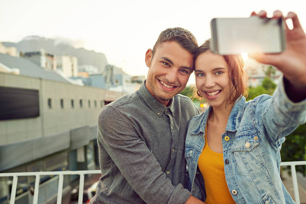 Sorridi, piccola. una giovane coppia felice che si fa un selfie insieme in città - Foto, immagini