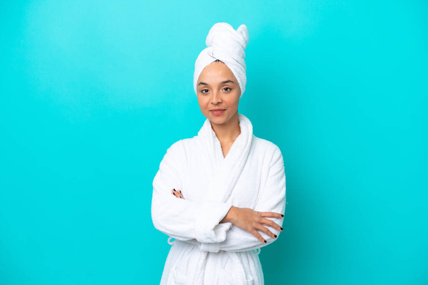 Young woman in a bathrobe with towel isolated on blue background - Foto, afbeelding