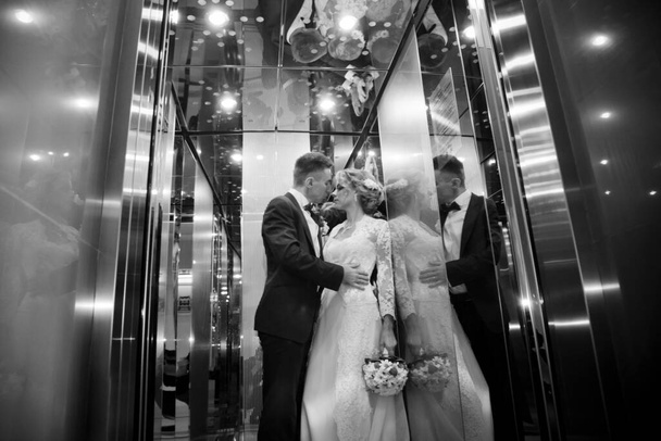 Молода красива пара в синьому костюмі і біла весільна сукня з букетом
 - Фото, зображення