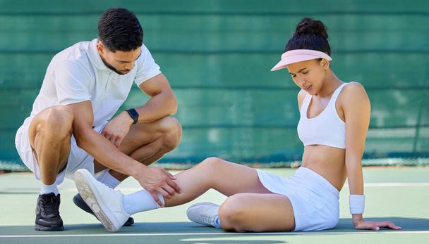 テニス選手、男性と女性と怪我の足、トレーニングでテニスコートでのヘルプとケア。コーチ、指導者やトレーニングマッチで女の子を助ける、スポーツや痛みとゲーム、筋肉やトレーニングで緊急時. - 写真・画像