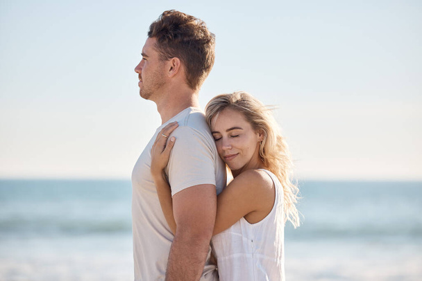 Couple, hug and love with travel to the beach and quality time together for care in relationship and bonding. Man, woman and trip to the ocean, peace and trust, support and growth with romantic date - Photo, Image