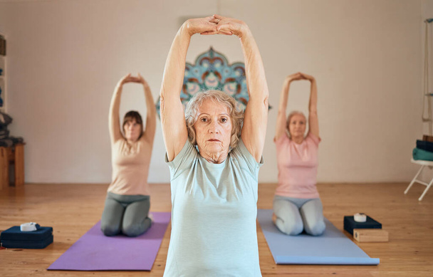 jogi, rozciąganie i starszych kobiet klasy fitness, motywacji zdrowotnej i ciała wellness w studio zdrowia. Medytacja zen, energia czakry i seniorzy wyciągają ręce do ćwiczeń. - Zdjęcie, obraz