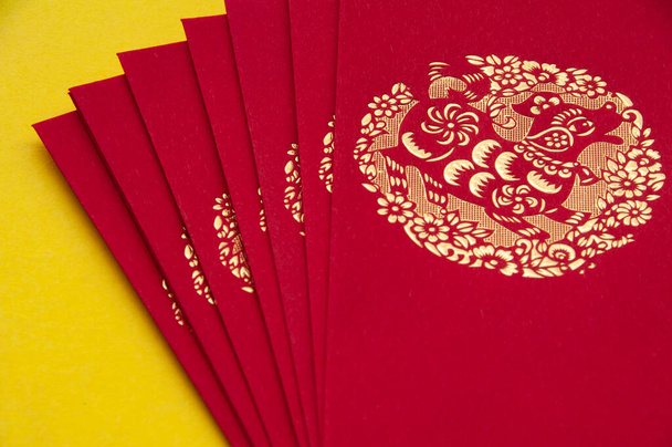 Red envelope on yellow cover background. Monetary gift given during special occasions such as Chinese New Year, birthday, weddings. - 写真・画像