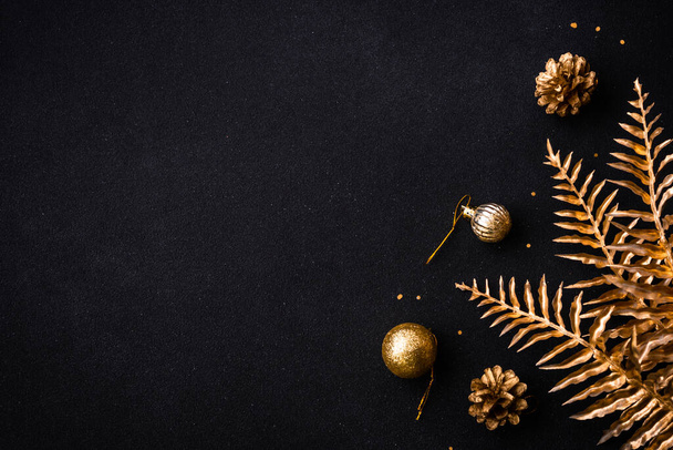 Christmas flat lay background with golden holiday decorations. Top view on black with copy space. - Fotografie, Obrázek