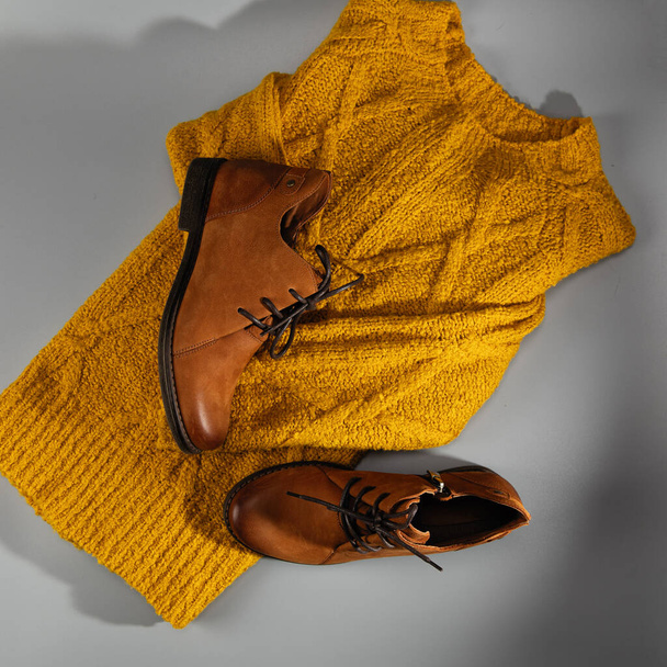 Női bőr cipő, kényelmes elegáns sárga nubuck csizma, új kollekció, koncepció, meleg sárga pulóver, elrendezés, felülnézet, közelkép szürke háttér - Fotó, kép