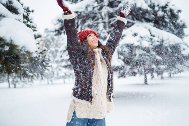 Happy woman  enjoying first snow in the forest. Holidays, rest, travel concept - Фото, изображение