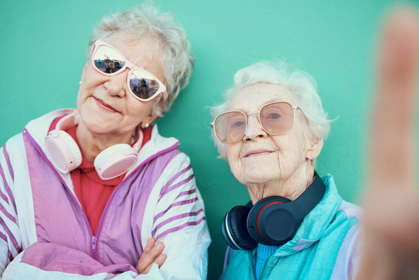 Idősebb nők, divat és retro szelfi napszemüveggel, fejhallgatóval és vintage ruhákkal, menő kültéri gondolkodásmóddal. Esztétikai idős emberek vagy barátok portréja pop art profilképhez. - Fotó, kép