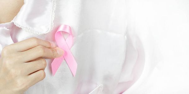 женщина держит ленточку, чтобы просветить о розовом раке, здравоохранении и медицине . - Фото, изображение