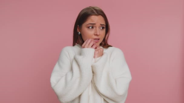 Upset scared frightened young woman biting nails, feeling worried nervous about serious troubles, stress and anxiety disorder, panic attack guilty. Caucasian girl isolated on studio pink background - Footage, Video