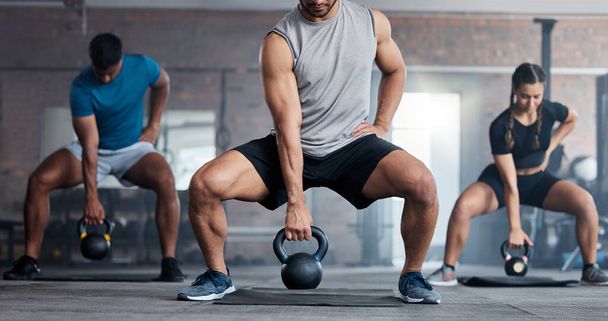 Fitness, weightlifting and kettlebell class for arm workout, exercise or training together at the gym. Active people in sports exercising with kettle weights for healthy cardio endurance or wellness. - Photo, Image