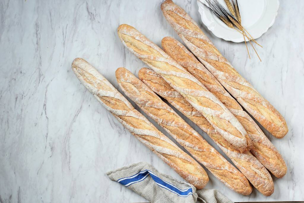 Freshly Baked French Soft Baguettes on White Marble Table. Top View with Copy Space - Photo, image