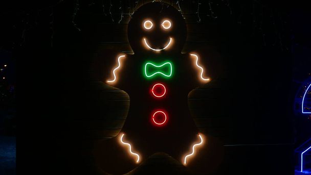 Уличное Рождество, новогоднее украшение из свинцовых ламп в виде пряничного человечка. Крупным планом, вечером, на улице - Фото, изображение