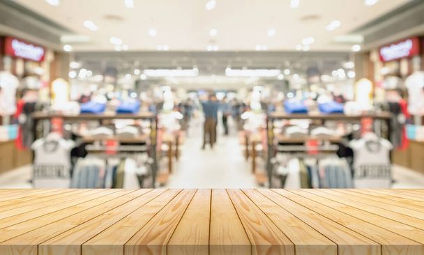 Üres fa asztal tetején elmosódott ruházat butik kijelző belső bevásárlóközpont háttér - Fotó, kép