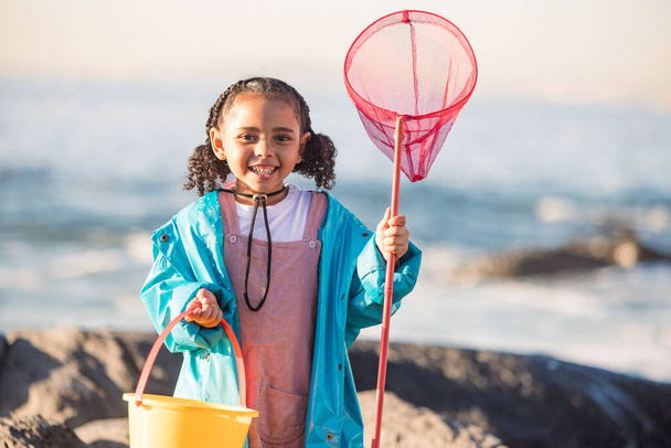 Fishing, beach and girl excited for adventure, freedom and holiday by the ocean in Australia. Equipment, happy and portrait of a child with smile to catch fish by the ocean during a vacation. - Photo, Image