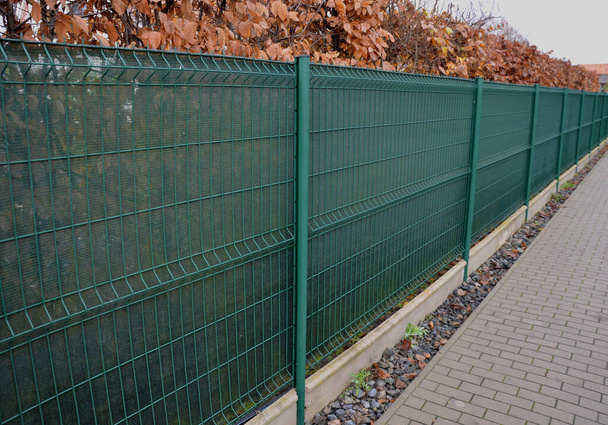 the shading fabric on the wire fence creates a private space and in a moment you have an opaque fence from annoying neighbors and views from the street, construction site, asphalt hornbeam hedge - Photo, Image