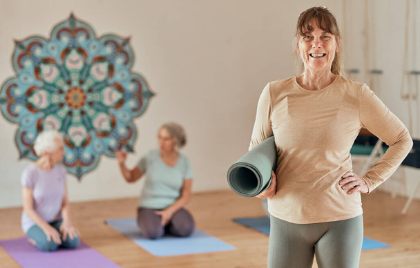 Yoga, mat and portrait of a senior woman in zen studio for a mind and body wellness workout. Happy, smile and calm elderly female pensioner standing ready for pilates or meditation exercise in studio. - Photo, Image