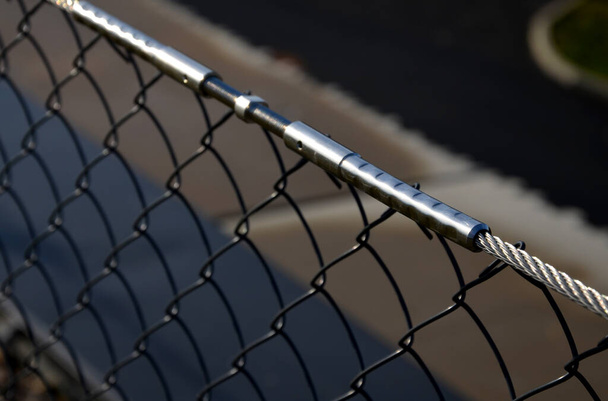 wire mesh fencing with a stainless steel guide wire and a tensioning mechanism with a threaded structural solution. detailed solution for tensioning the cable of the railing fence - Photo, Image
