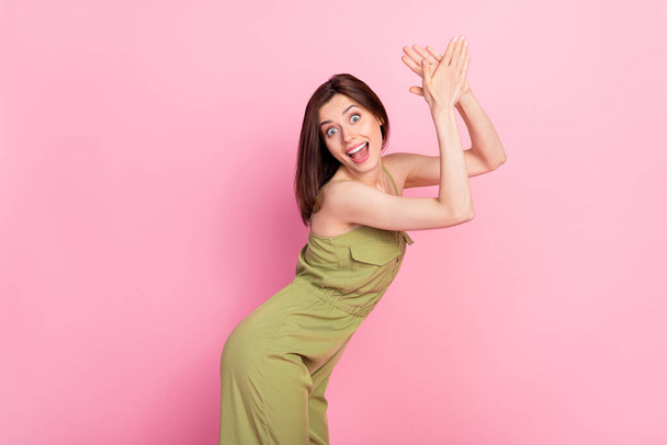 Profil fotografie Hurá bruneta dáma tleskat ruce nosit khaki celkově izolované na růžové barevné pozadí. - Fotografie, Obrázek