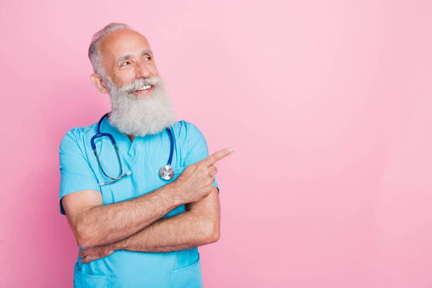 Photo of man cardiologist demonstrate finger empty space offer clinic diagnostics isolated on pastel color background. - Foto, afbeelding