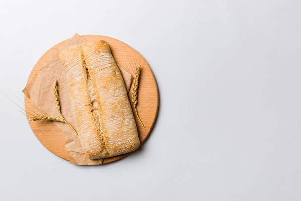 Свіжоспечений хліб на обробній дошці на білому дерев'яному фоні. хліб зверху з копією простору
. - Фото, зображення