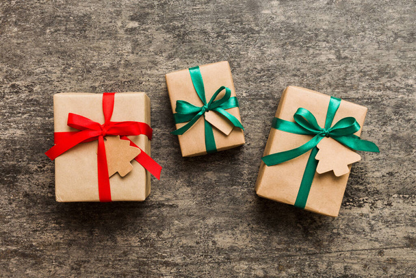 Цветные ремесленные подарочные коробки с красочными лентами на цветном фоне. Коллекция рождественских подарков . - Фото, изображение