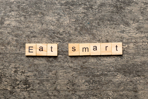 Essen Sie intelligentes, auf Holzklötze geschriebenes Wort. Smart Text auf Zementtisch essen für Ihre Gestaltung, Konzept von oben. - Foto, Bild
