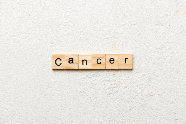 Slovo CANCER napsaný na dřevěném špalku. CANCER text na betonovém stole pro vaše desing, koncept. - Fotografie, Obrázek