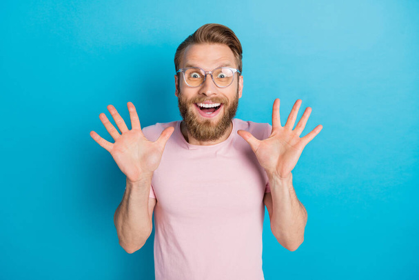 Photo portrait of nice young man spectacles excited astonished news raise palms wear trendy pink garment isolated on cyan color background. - Photo, Image