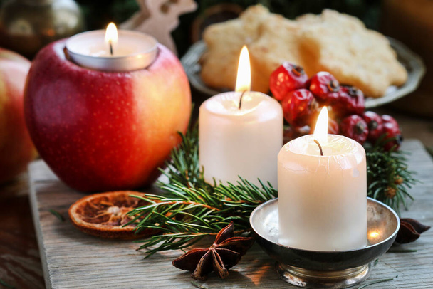 Beautiful candles and other traditional Christmas decorations on the table. Festive time - Фото, изображение
