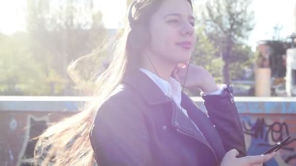młoda dziewczyna w słuchawki słuchać muzyki - Materiał filmowy, wideo