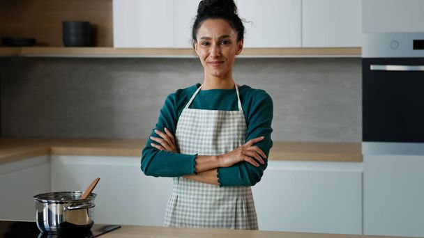 Bela fogão árabe chef padeiro dona de casa étnica jovem vegetariana posando na cozinha moderna retrato feminino da senhora espanhola satisfeita mãe preparar refeição para a família de pé com os braços cruzados - Foto, Imagem