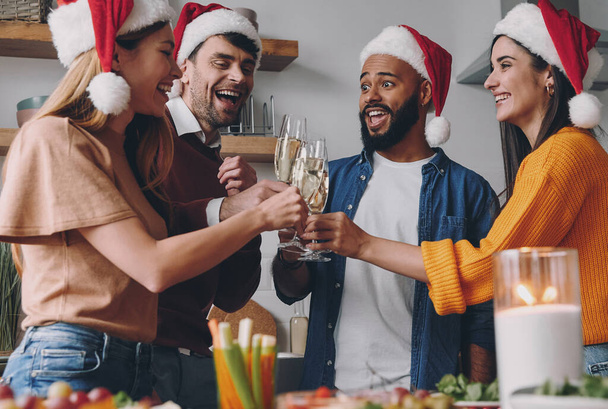 Cheerful people toasting with champagne while enjoying Christmas dinner at home - Photo, Image