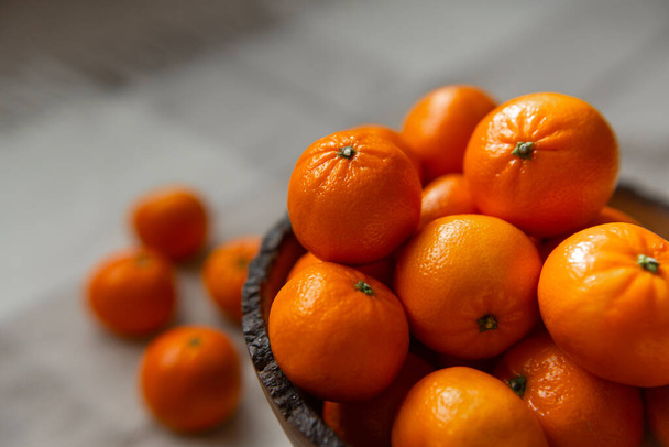 Mand met mandarijn of sinaasappel fruit op een grijze geruite achtergrond. - Foto, afbeelding