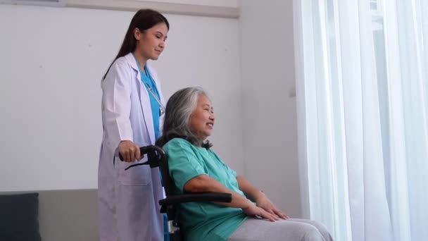 Asiatique médecin féminin traite les patients âgés souffrant de dépression. Elle était assise dans un fauteuil roulant. Le concept de patients âgés. Centre de santé pour personnes âgées - Séquence, vidéo