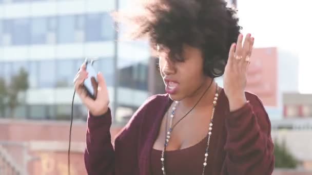 Szczęśliwa dziewczyna Afryki słuchania muzyki - Materiał filmowy, wideo