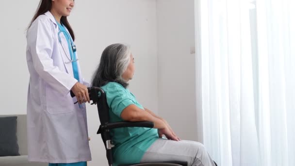 Азиатская женщина-врач лечит пожилых пациентов, страдающих от депрессии. Она сидела в инвалидном кресле. Концепция пожилых пациентов. Центр помощи пожилым людям - Кадры, видео