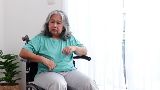 Азиатская пожилая женщина, сидящая в инвалидном кресле, страдает от стресса и депрессии. Жить одной дома. Концепция пожилых пациентов, депрессивные расстройства у пожилых людей. - Кадры, видео