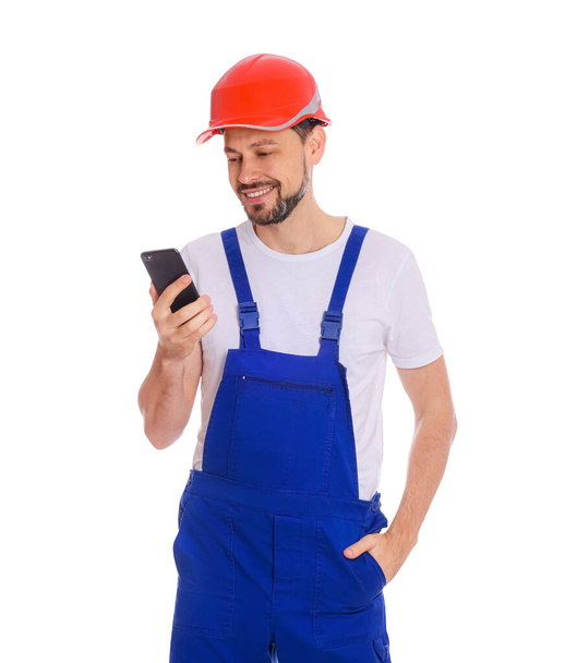 Professional repairman in uniform with phone on white background - Фото, зображення