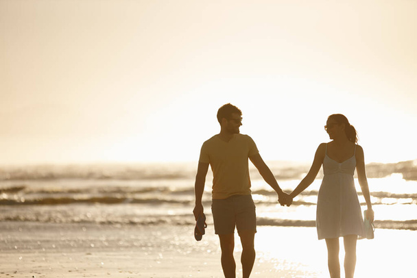 Романтические моменты. счастливая пара наслаждается прогулкой вместе по пляжу на рассвете - Фото, изображение