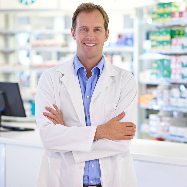 Your friendly and experienced local pharmacist. Portrait of a handsome pharmacist standing at the prescription counter - Foto, Imagem