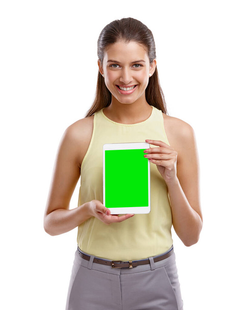 Go on, have a look. Studio shot of a beautiful young woman holding up a digital tablet with a chroma key screen against a white background - Foto, afbeelding