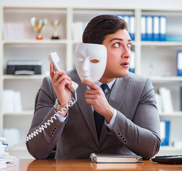 オフィス偽善の概念でマスクを持つビジネスマン - 写真・画像
