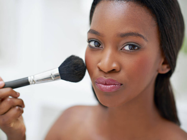 Brush with beauty. a beautiful young woman applying blush with a makeup brush - Fotó, kép