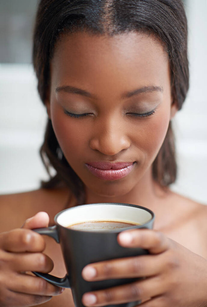 Smells like heaven. A young ethnic woman enjoying a cup of coffee - Φωτογραφία, εικόνα