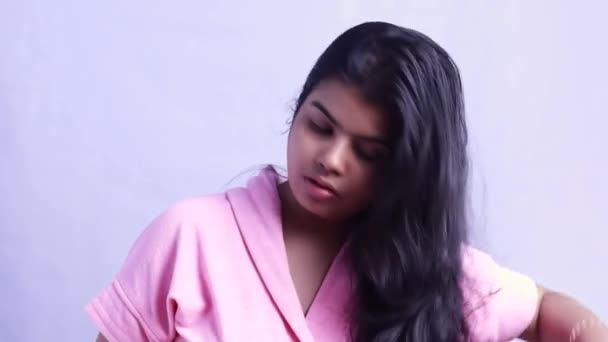 Egy csinos indiai nő aggódik a hatalmas hajhullás probléma közben fésülködés haját fehér háttér - Felvétel, videó