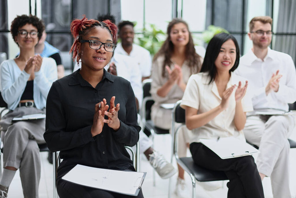 Selective focus of young businesswoman applauding together with interracial colleagues during seminar, banner - Foto, immagini