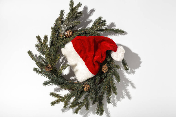 Sombrero rojo de Santa Claus aislado de arriba sobre fondo colorido con luz de alto contraste. Acostado. vista superior - Foto, imagen